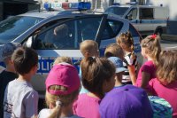 Policjant pokazuje dzieciom radiowóz