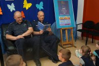 Policjanci czytają dzieciom w bibliotece