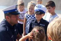 Policjant rozmawia z dziećmi o bezpieczeństwie na drodze