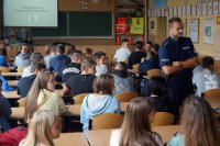 Policjant rozmawia z młodzieżą o bezpieczeństwie w sieci