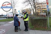 Policjant wręcza odblaski pieszej