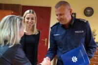 Pani Monika odbiera gratulacje z rąk Komendanta Miejskiego Policji w Żorach i nagrodę, którą przekazała Pani Anna Ujma