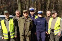 Policjanci i strażnicy leśni podczas wspólnej akcji, zdjęcie grupowe z Naczelnikiem Wydziału Ruchu Drogowego