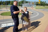 Policjant z chłopcem prezentującym tarczę ochronną