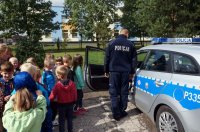 Policjanci prezentują przedszkolakom radiowóz