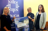 Po lewej Monika Grudziecka-Stefaniak, po prawej policjantka i Agnieszka Spyrka, w tle rollup z logo Policji