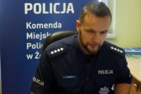 Policjant siedzi pochylony przed laptopem