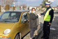 Policjant wręcza kierującej ulotkę