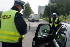 Policjanci rozmawiają z zatrzymanym do kontroli kierowcą
