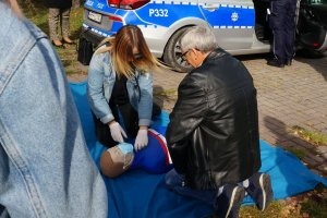 Uczennica instruuje mężczyznę jak udzielać pierwszej pomocy