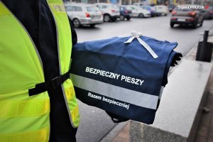 Policjant trzyma torbę z odblaskami