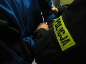 Policjant prowadzi zatrzymanego