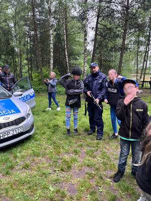 Dzieci pozują z policjantem w ubraniach szturmowych