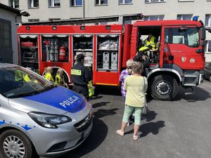 Radiowóz i pojazd strażacki oraz przedszkolaki