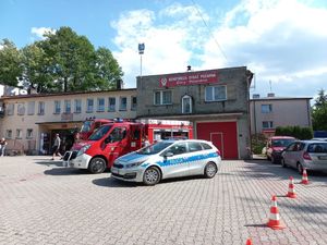 Radiowóz oraz wóz strażacki na tle Ochotniczej Sytraży Pożarnej