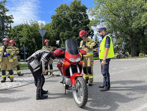 Policjant ocenia uszkodzenia motocykla