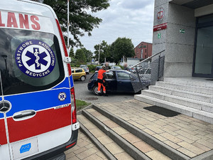 Karetka pogotowia na tle żorskiej Policji