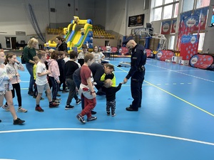 Na zdjęciu widać grupę osób oraz policjantów rozdających odblaski