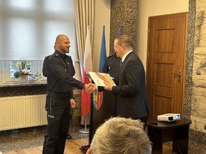 Na zdjęciu widać odprawę żorskiej Policji, Prezydent Miasta składa list gratulacyjny nadkom. Tomaszowi Walkowskiemu za wkład w poprawę bezpieczeństwa i długoletnią służbę.