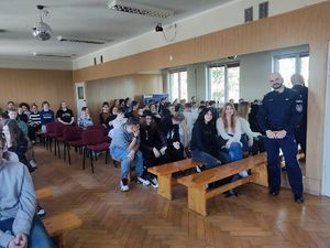 Na zdjęciu widać policjanta oraz uczniów w trakcie spotkania profilaktycznego.