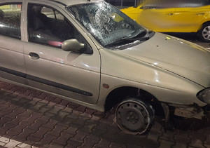 Na zdjęciu widać uszkodzony samochód osobowy, prawe przednie koło posiada samą felgę bez opony.
