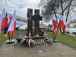 Na zdjęciu widać pomnik, a także złożone pod nim kwiaty.