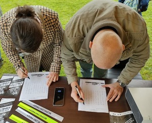 Na zdjęciu widać kobietę i mężczyznę, którzy wypełniają test przygotowany przez mundurowych.