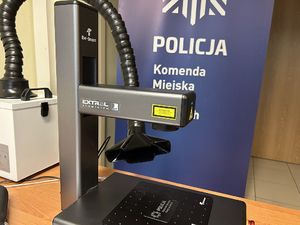 Na zdjęciu widać urządzenie znakujące, a w tle rollup z logotypem żorskiej Policji.