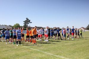 Na zdjęciu widać drużyny w gotowości do rywalizacji sportowej.