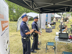 Na zdjęciu widać policjantów ruchu drogowego przed stanowiskiem znakowania rowerów.