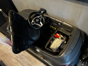 Na zdjęciu widać akumulatorowy samochód dziecięcy, pod którego siedzeniem znajduje się worek z zawartością białego proszku.