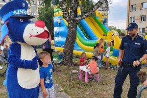 Na zdjęciu widać policjanta, Sznupka oraz uczestników sportowego pikniku.