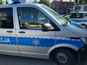 Na zdjęciu widać policyjny radiowóz a w pojeździe dwóch policjantów.