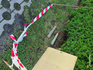 Na zdjęciu widać leżące na trawie dwa niewybuchy, miejsce odgrodzone jest biało-czerwoną taśmą.