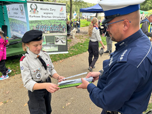 Na zdjęciu widać harcerkę otrzymującą odblask od policjanta.