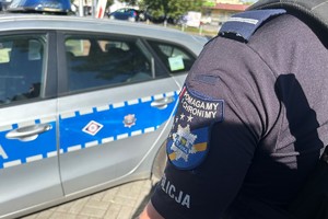 Na zdjęciu widać policjanta przed radiowozem.