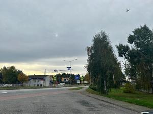 Na zdjęciu widać rejon przejścia dla pieszych na drodze dwujezdniowej oraz drona &quot;wiszącego&quot; w powietrzu.
