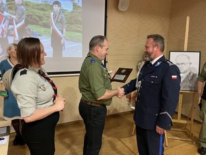 Na zdjęciu widać jak Komendant Chorągwi Śląskiej Hm. Marcin Różycki, w asyście komendantki hufca ZHP Żory Hm. Anny Buksy wręcza odznaczenie Komendantowi Miejskiemu Policji w Żorach.