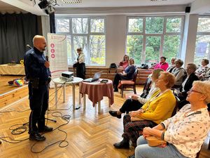 Na zdjęciu widać policjanta, który przemawia podczas konferencji amzonek.