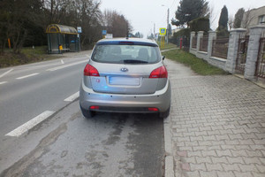 Na zdjęciu widać szary samochód, przejście dla pieszych oraz okoliczną zabudowę mieszkalną.