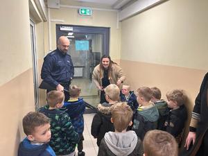 Na zdjęciu widać policjanta, nauczycielkę oraz dzieci.