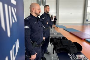 Na zdjęciu widać policjantów przed stanowiskiem promującym służbę w Policji.