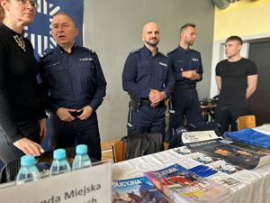 Na zdjęciu widać przedstawicieli Policji oraz osoby zainteresowane służbą przy stanowisku wystawienniczym.