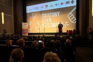 Na zdjęciu widać Komendanta na scenie oraz salę kina wypełnioną uczestnikami.