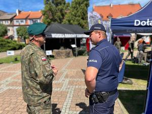 Na zdjęciu widać policjanta oraz żołnierza stojących przy namiocie żorskiej Policji.