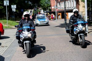 Na zdjęciu widać policjantów na motocyklach, a za nimi pochód.