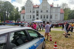 Na zdjęciu widać policyjny radiowóz, pojazdy strażackie oraz Pałac Baranowice.