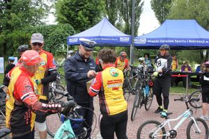 Na zdjęciu widać policjanta oraz kolarzy ubranych w żółte bluzki.