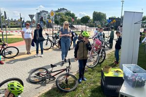 Na zdjęciu widać rowerzystów w kaskach przed stanowiskiem promocyjnym żorskiej Policji.