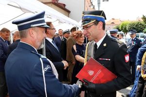 Na zdjęciu widać Komendanta Państwowej Straży Pożarnej składającego gratulacje na ręce Komendanta Miejskiego Policji w Żorach.